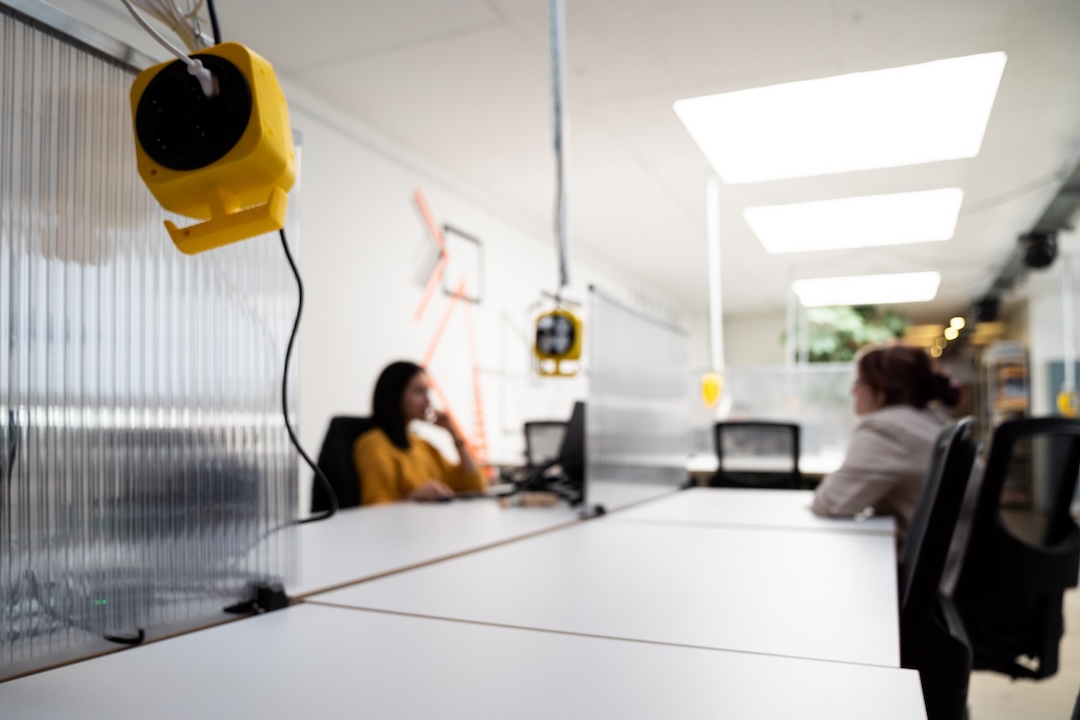 An großen Schreibtischen können Coworker:innen ihrer Arbeit nachgehen